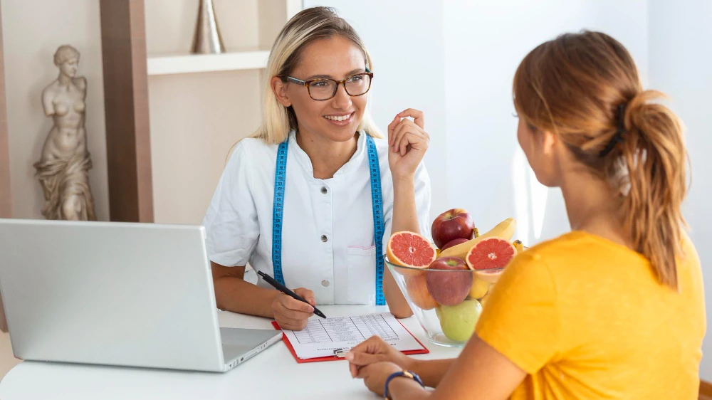 Compassionate dietitian and client consultation in a calm clinic setting supporting eating disorder care and personalised nutrition guidance.